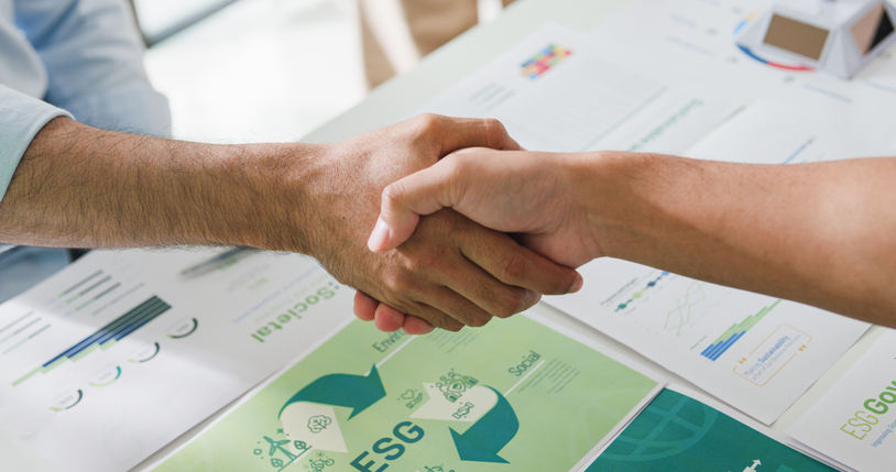 closeup businesspeople shaking hands over esg strategic commitment workshop, sdgs report, global warming, green finance investment eco friendly and net zero waste in boardroom training building. ESG Goals